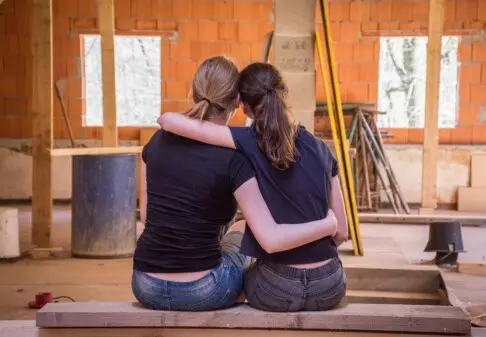 2 Frauen sitzen auf Bank im Rohbau