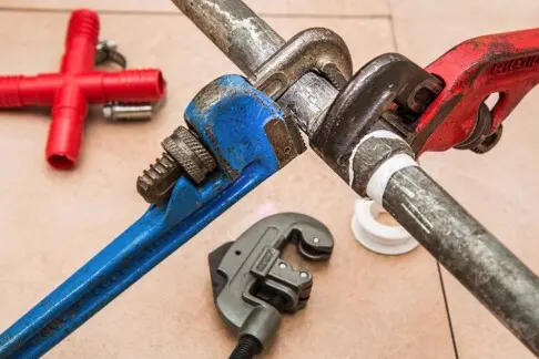 Metallrohr und Rohrzange in blau und rot